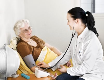 Senior lady having his blood pressure checked by a doctor